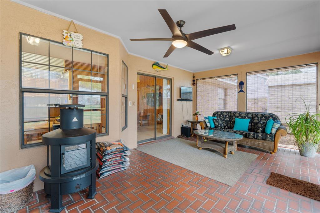 14334 Raintree Boulevard Grand Island, FL 32735 - Photo 32 of 40 a living room with furniture a chandelier and a floor to ceiling window