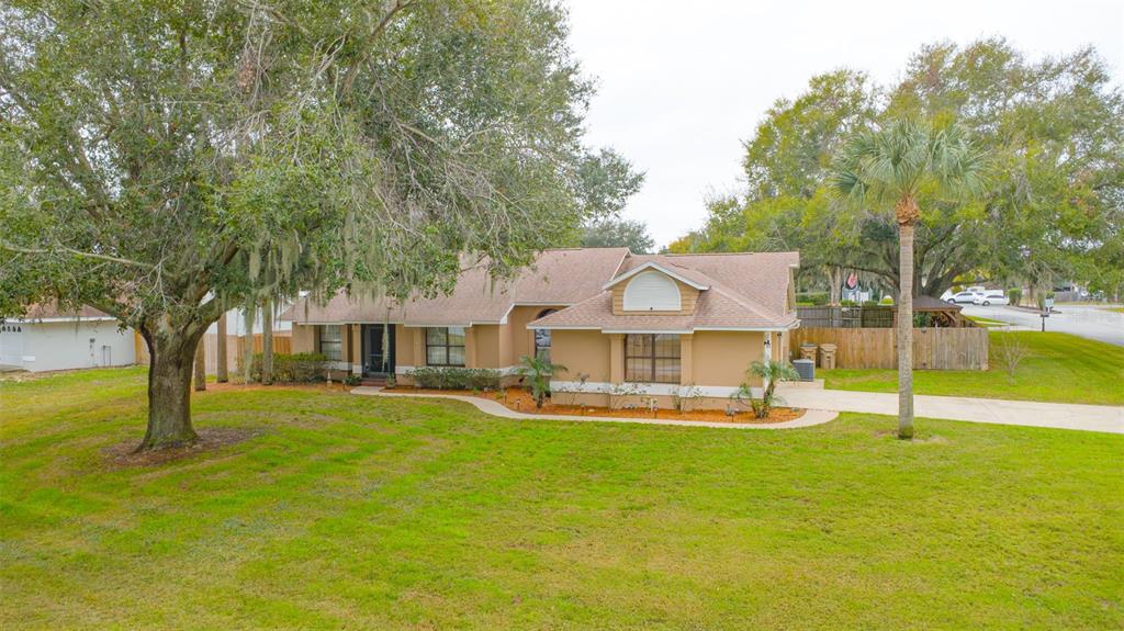 14334 Raintree Boulevard Grand Island, FL 32735 - Photo 4 of 40 a front view of a house with a yard garage and outdoor seating