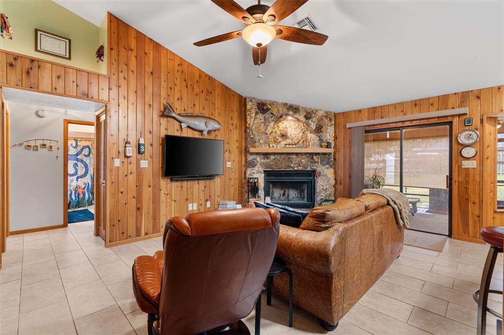 14334 Raintree Boulevard Grand Island, FL 32735 - Photo 9 of 40 a living room with furniture a flat screen tv and a fireplace