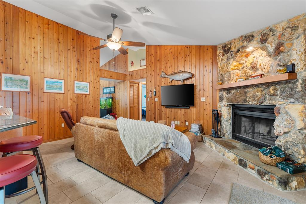 14334 Raintree Boulevard Grand Island, FL 32735 - Photo 10 of 40 a living room with furniture a flat screen tv and a fireplace
