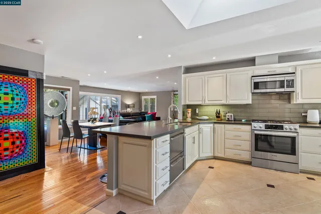 a kitchen with stainless steel appliances granite countertop a refrigerator a stove top oven a sink dishwasher and cabinets with wooden floor