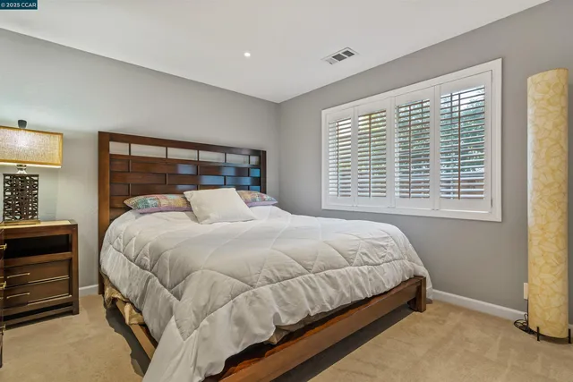 a bed sitting in a bedroom next to a window