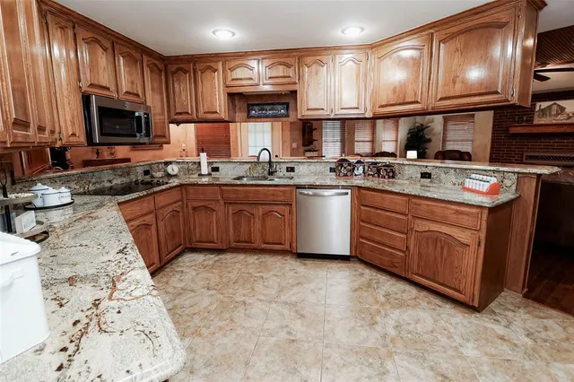 a kitchen with stainless steel appliances granite countertop a sink stove and microwave