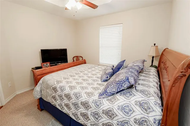a bed sitting in a bedroom next to a window with tv