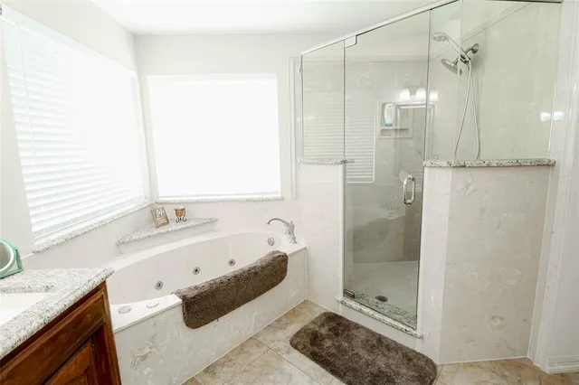 a bathroom with a granite countertop sink a mirror and a shower