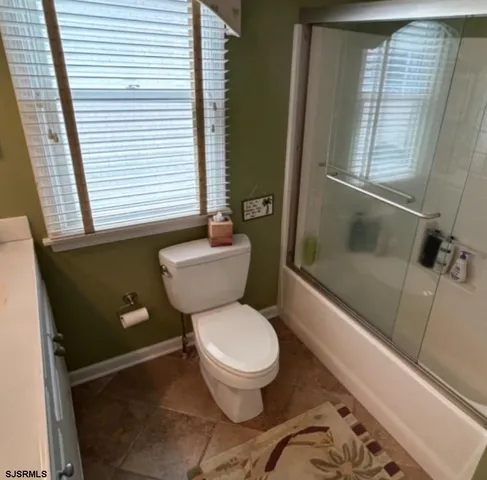 a white toilet sitting next to a bathroom sink