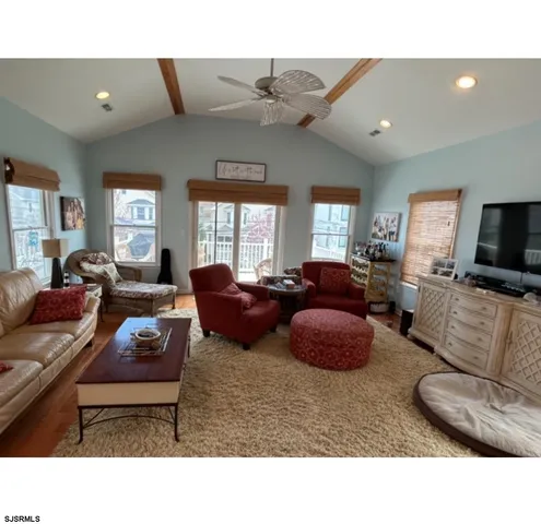 a living room with furniture a ceiling fan and a window