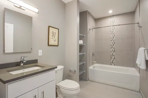 a bathroom with a granite countertop sink a toilet and shower