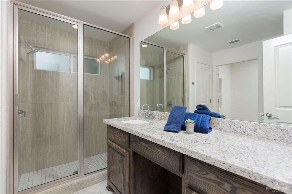 14337 Chalk Rdg Drive McAllen, TX 78504 - Photo 15 of 21 Modern bathroom featuring a granite vanity, spacious walk-in shower and sleek finishes for a spa-like feel