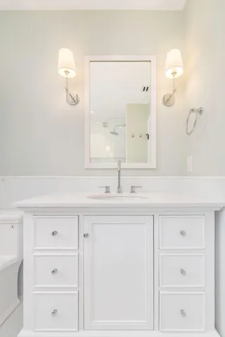 a bathroom with a sink a toilet and a mirror