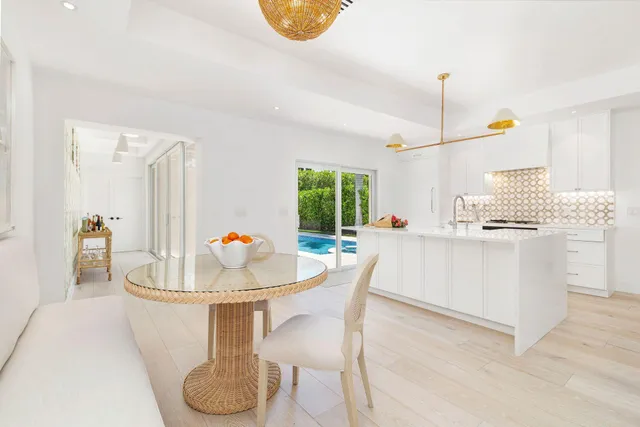 a living room with kitchen appliances furniture and a chandelier