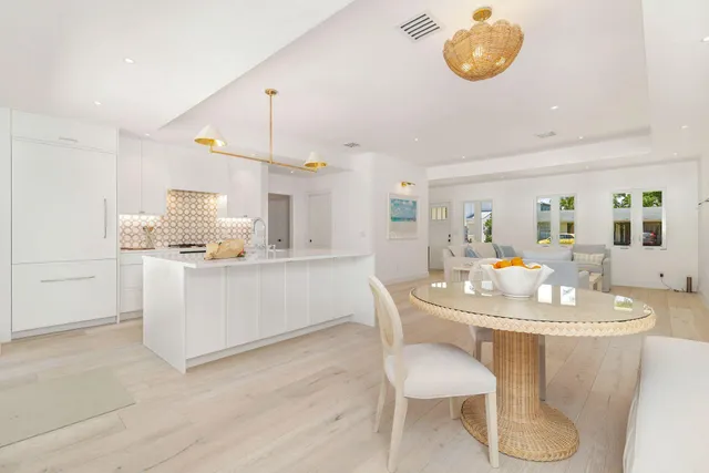 a kitchen with a dining table chairs and white cabinets