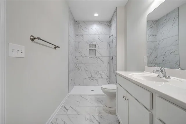 a bathroom with a sink a toilet and shower