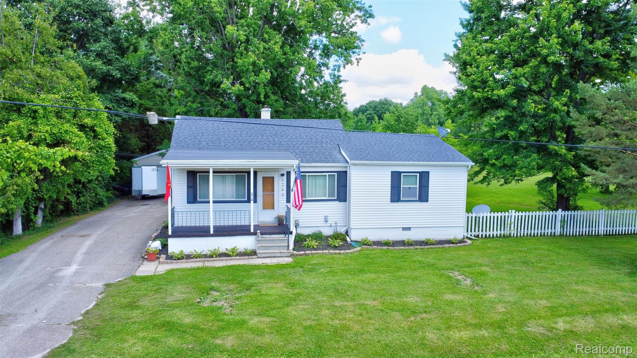 5244 Oleksyn Road Flint, MI 48504 - Photo 1 of 70 White siding exterior with a dark shingle roof and a covered front porch
