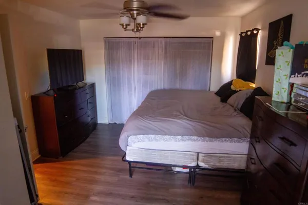 a bedroom with a bed and a flat tv screen on dresser