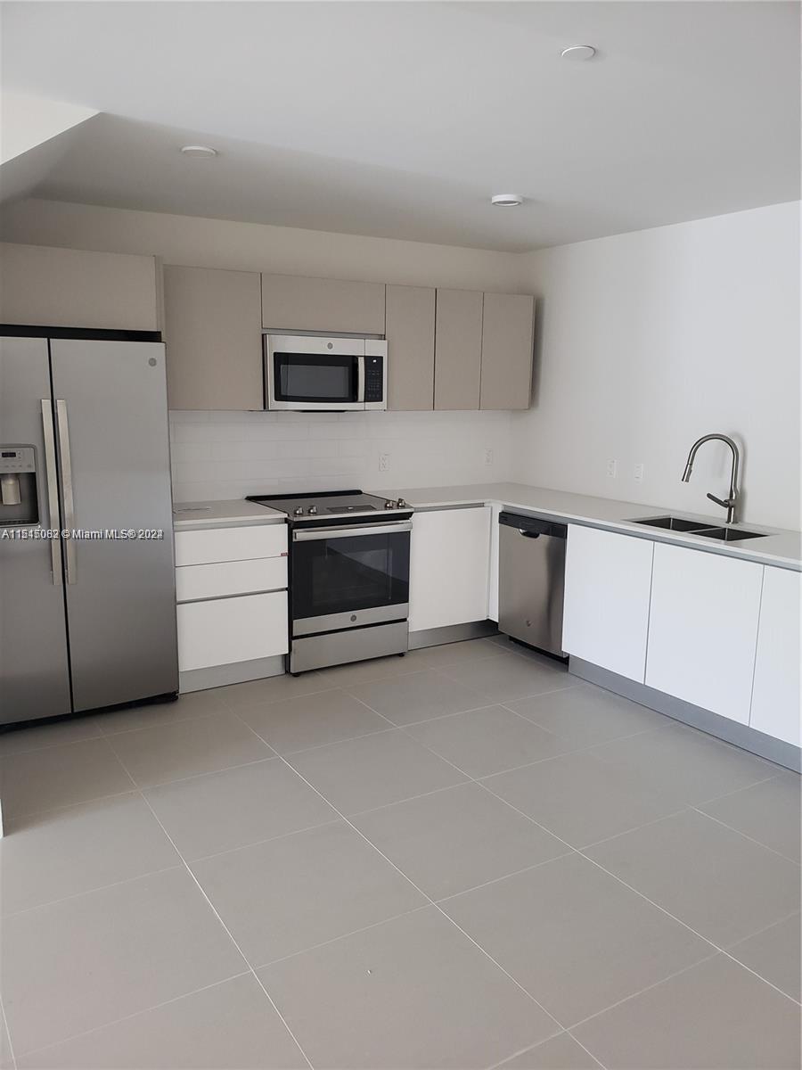 a kitchen with stainless steel appliances a sink and a refrigerator