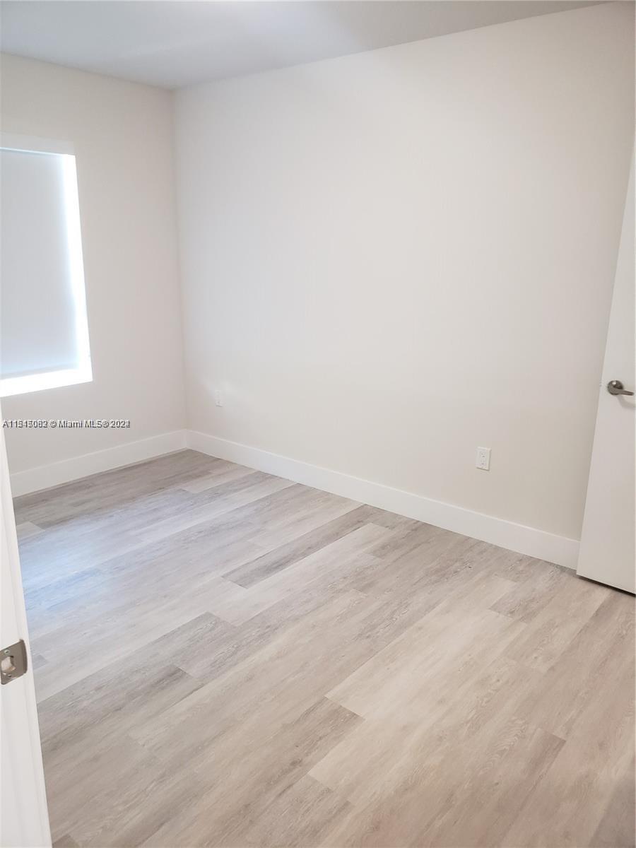 Ojus Miami, FL 33180 - Photo 4 of 13 an empty room with wooden floor and windows