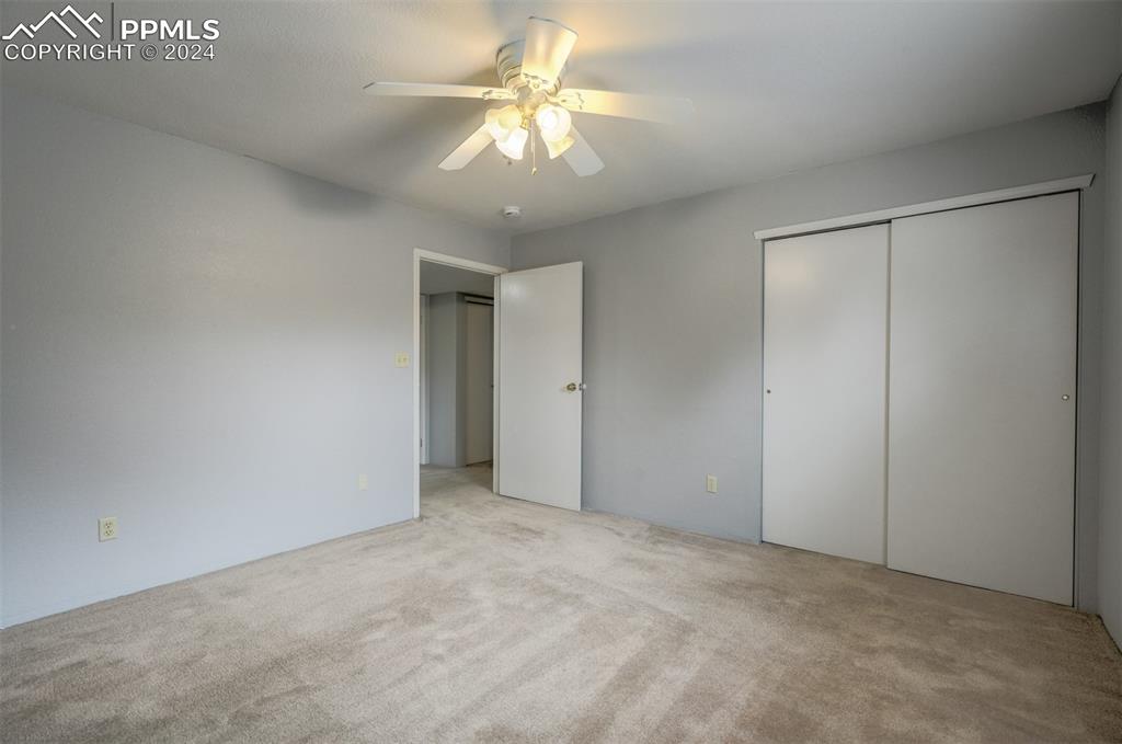 2195 Alicia Point, Unit 102 Colorado Springs, CO 80919 - Photo 21 of 36 a view of an empty room with a chandelier fan