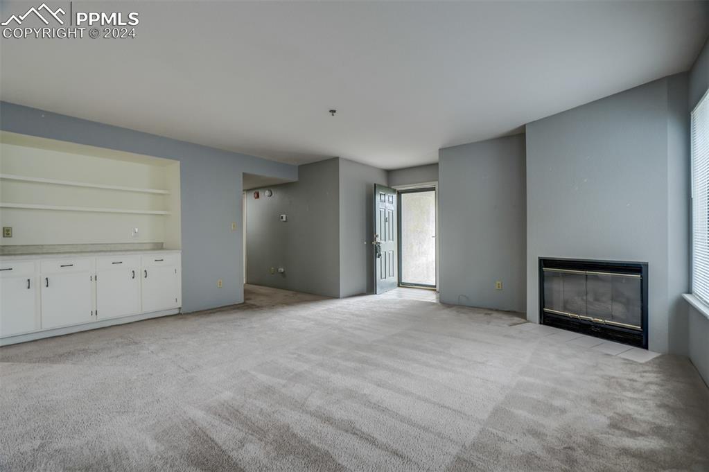 2195 Alicia Point, Unit 102 Colorado Springs, CO 80919 - Photo 7 of 36 a view of an empty room with a fireplace and a window