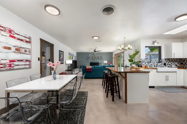 a kitchen with stainless steel appliances granite countertop a sink and a dining table