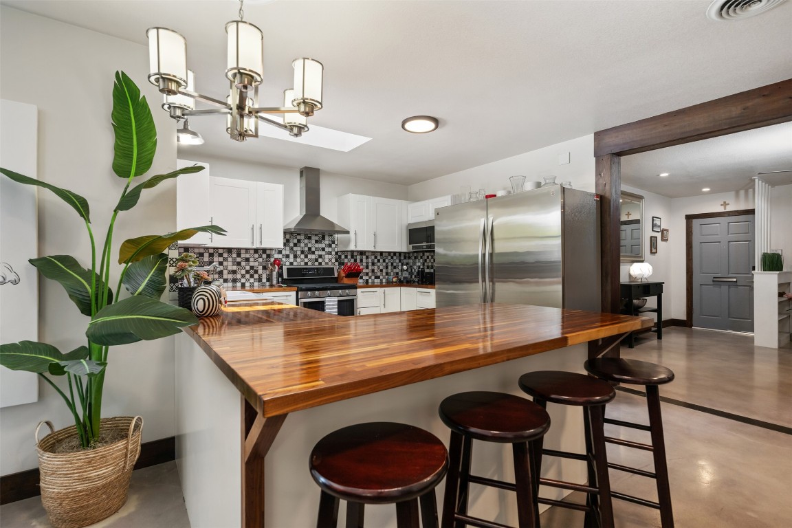 1806 Rogge Lane Austin, TX 78723 - Photo 13 of 40 a kitchen with stainless steel appliances granite countertop a sink and a dining table