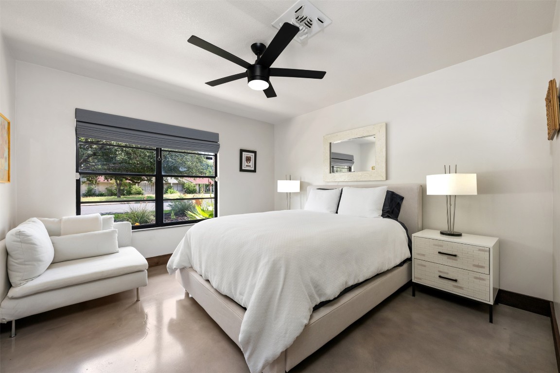 1806 Rogge Lane Austin, TX 78723 - Photo 17 of 40 a bedroom with a bed a couch and a large window