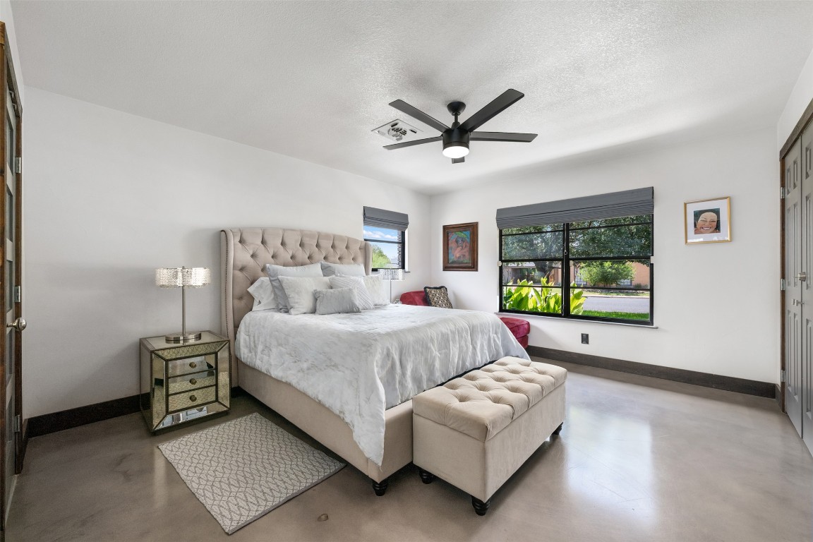 1806 Rogge Lane Austin, TX 78723 - Photo 22 of 40 a spacious bedroom with a bed a couch and a window