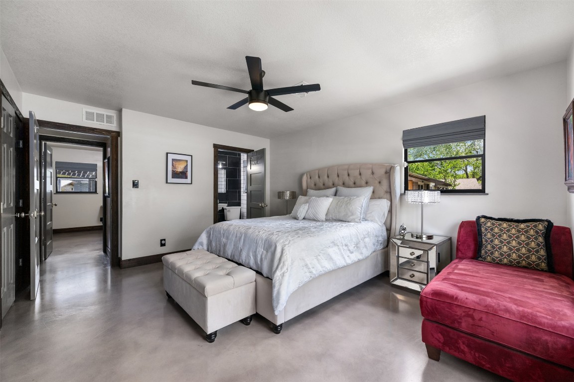 1806 Rogge Lane Austin, TX 78723 - Photo 23 of 40 a bedroom with a bed and a chandelier