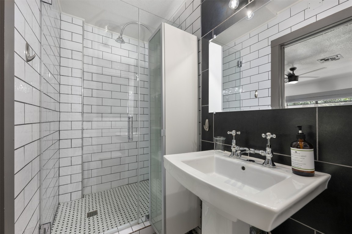 1806 Rogge Lane Austin, TX 78723 - Photo 26 of 40 a bathroom with a sink a mirror and shower