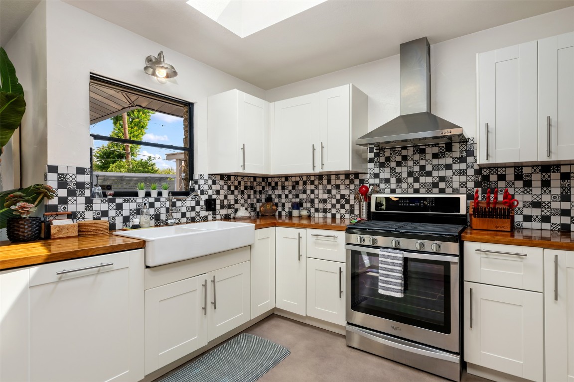 1806 Rogge Lane Austin, TX 78723 - Photo 3 of 40 a kitchen with stainless steel appliances granite countertop a stove a sink and a microwave