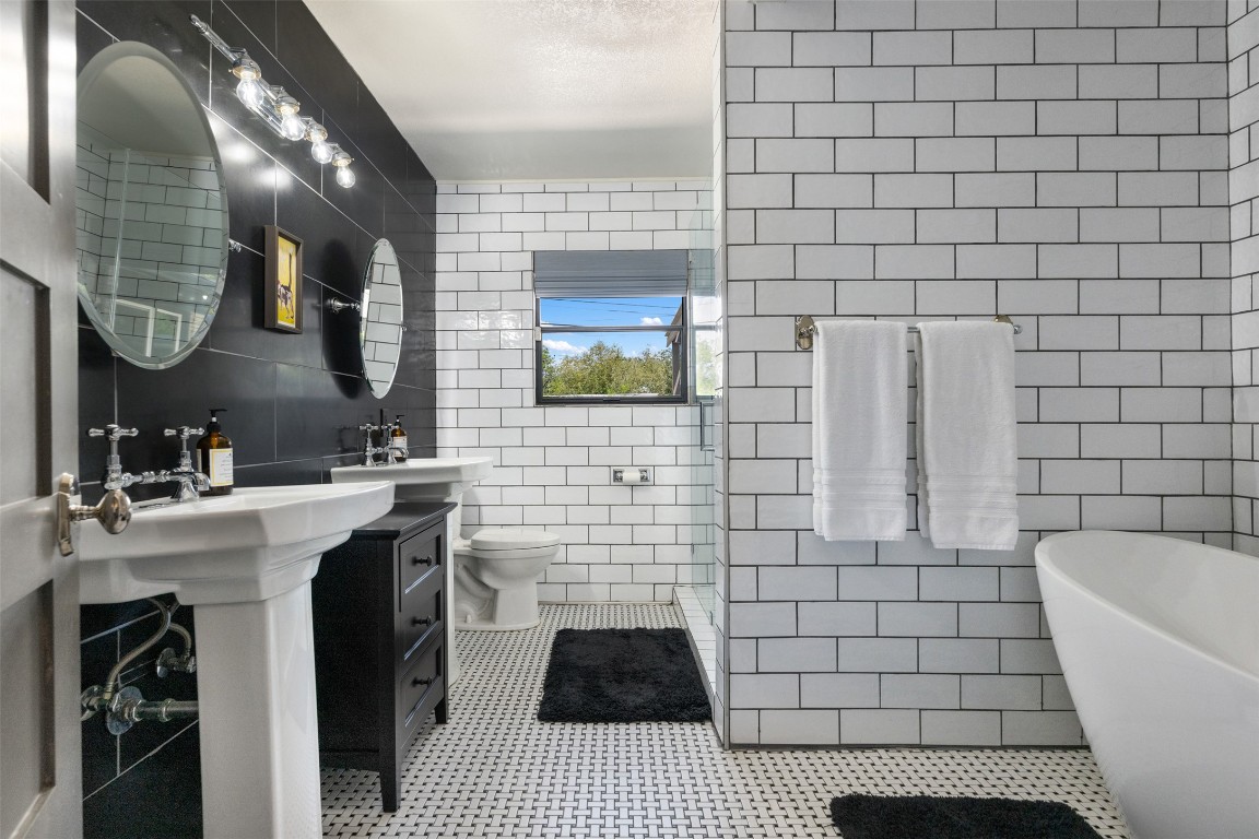 1806 Rogge Lane Austin, TX 78723 - Photo 5 of 40 a bathroom with a sink a toilet and mirror