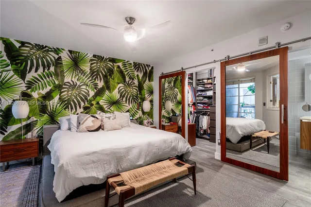 a bedroom with a large bed and a potted plant