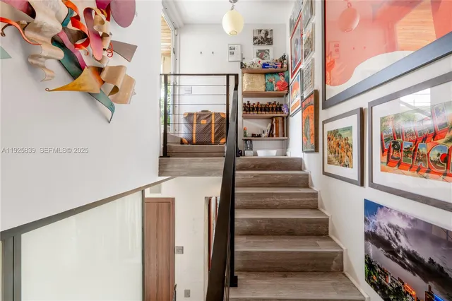 a view of a hallway with wooden floor and a chandelier