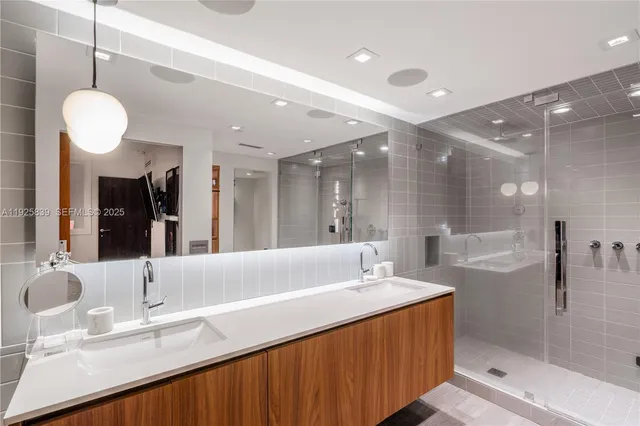 a bathroom with a double vanity sink mirror and shower