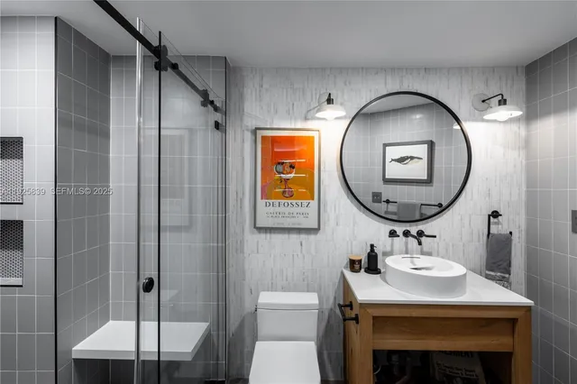 a bathroom with a sink a mirror a vanity and a shower