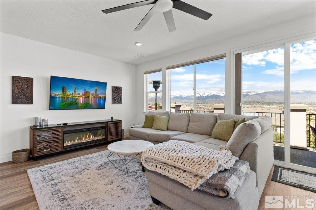 10385 Alchemy Court Reno, NV 89521 - Photo 12 of 40 a living room with furniture a flat screen tv and a large window