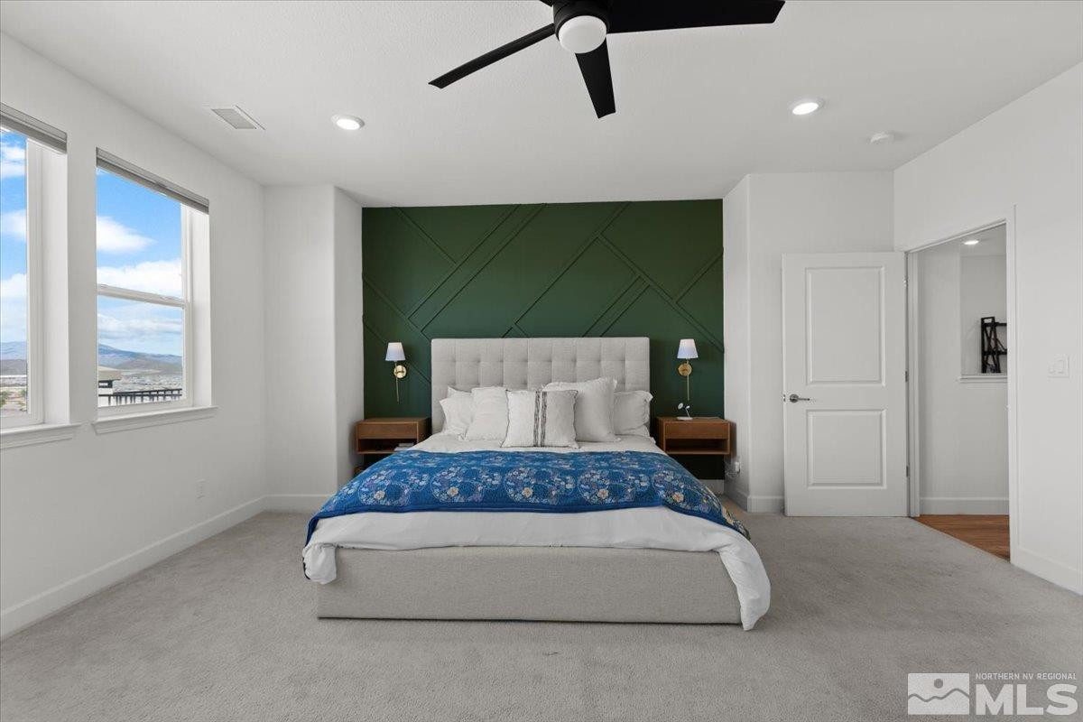 10385 Alchemy Court Reno, NV 89521 - Photo 15 of 40 a spacious bedroom with a large bed and a chandelier