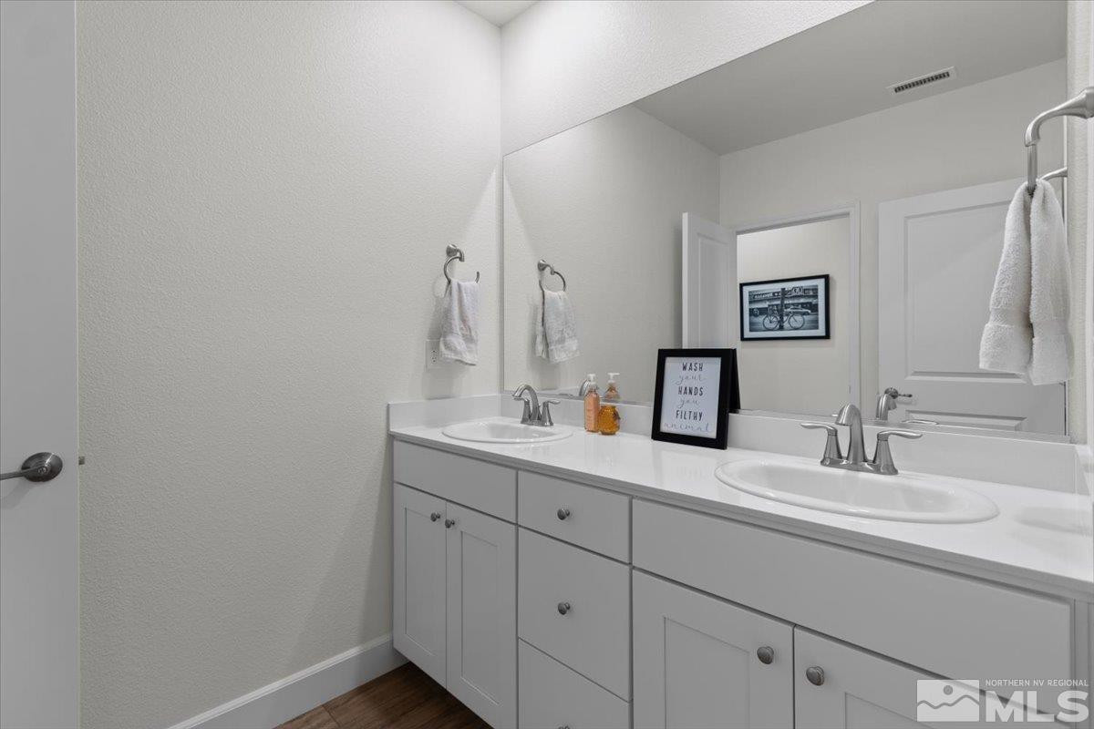 10385 Alchemy Court Reno, NV 89521 - Photo 23 of 40 a bathroom with a double vanity sink and a mirror