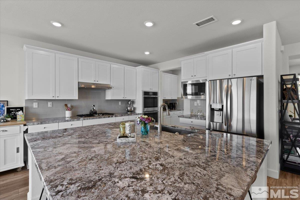 10385 Alchemy Court Reno, NV 89521 - Photo 6 of 40 a kitchen with sink refrigerator and cabinets