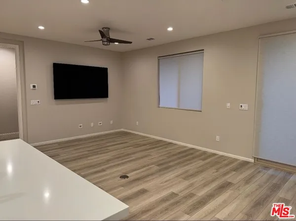a view of a livingroom with wooden floor and a flat screen tv