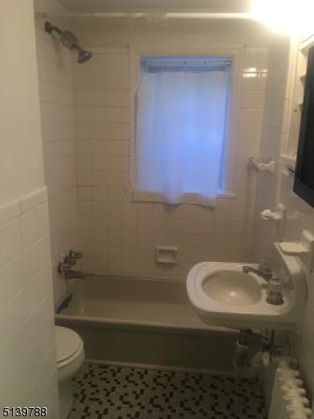 679 Mountain Boulevard, Unit 6 Watchung, NJ 07069 - Photo 12 of 13 a bathroom with a sink a toilet and shower