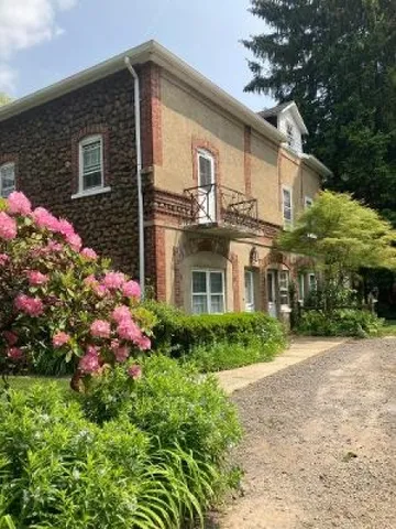 a front view of house and yard with beautiful flowers