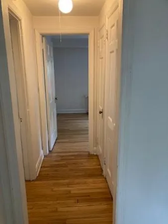 a view of a hallway with wooden floor and staircase