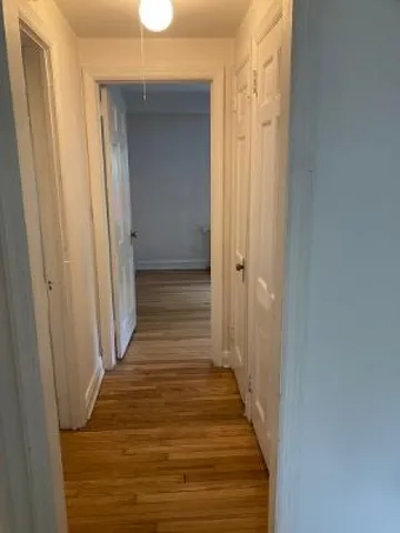 a view of a hallway with wooden floor and staircase