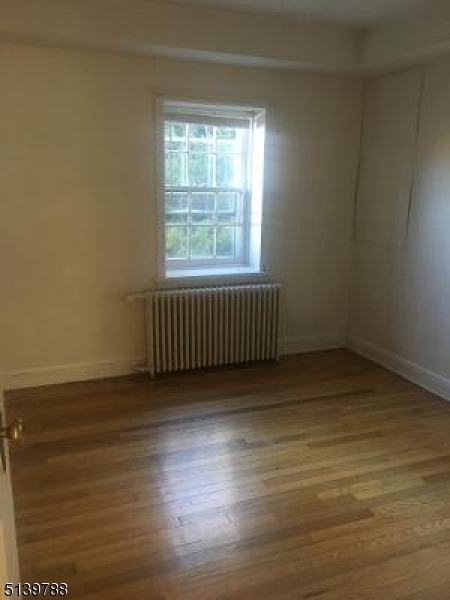679 Mountain Boulevard, Unit 6 Watchung, NJ 07069 - Photo 10 of 13 an empty room with wooden floor and windows