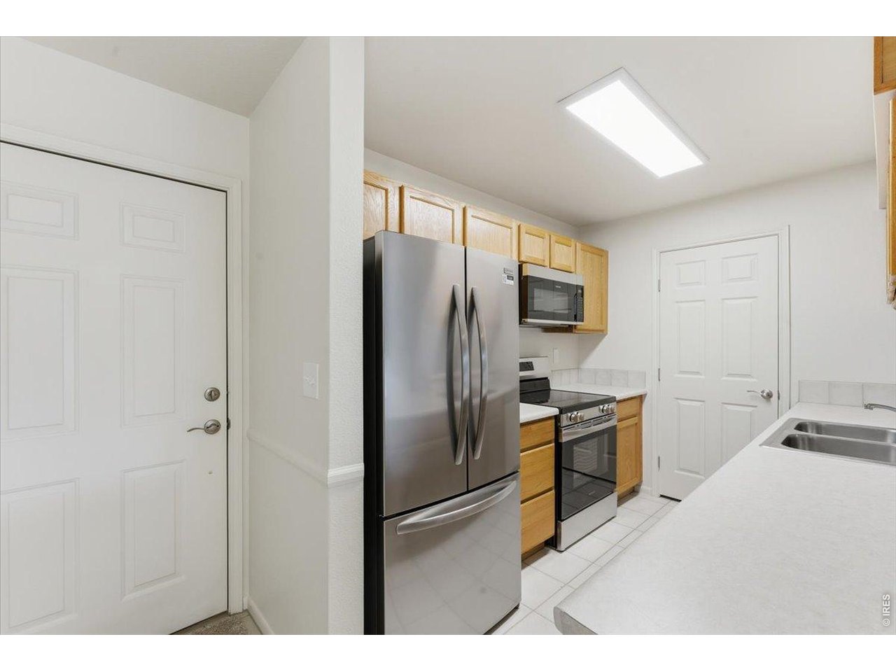 2551 West 24th Street, Unit A6 Greeley, CO 80634 - Photo 7 of 28 a kitchen with stainless steel appliances granite countertop a refrigerator and a sink