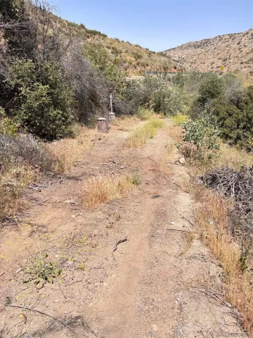 a view of a dry yard with mountains in the background