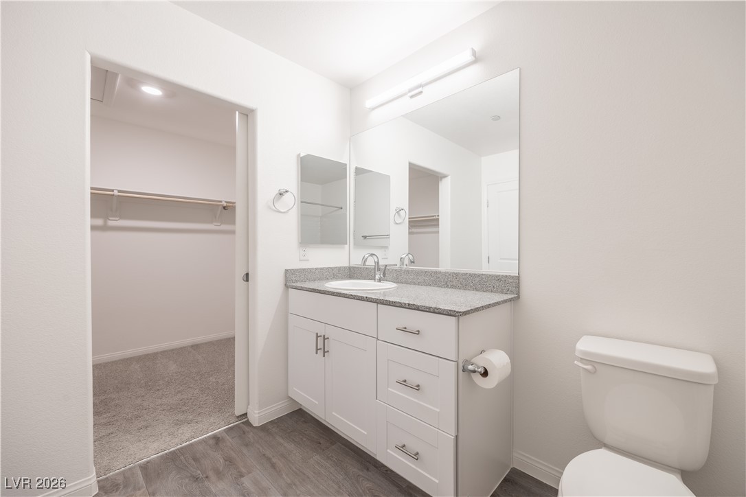 12185 Scarlet Ember Road, Unit 4 Las Vegas, NV 89183 - Photo 16 of 40 Bathroom featuring a spacious closet, vanity, and light wood-type flooring