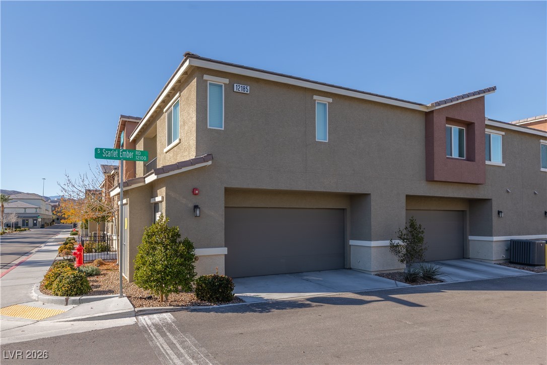 12185 Scarlet Ember Road, Unit 4 Las Vegas, NV 89183 - Photo 27 of 40 View of front of home featuring stucco siding, concrete driveway, and a garage