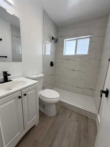 a bathroom with a sink a toilet and shower